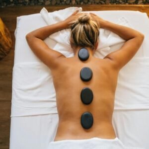 Smooth heated basalt stones placed on a client's back during a hot stone massage in Saint Martin SXM.