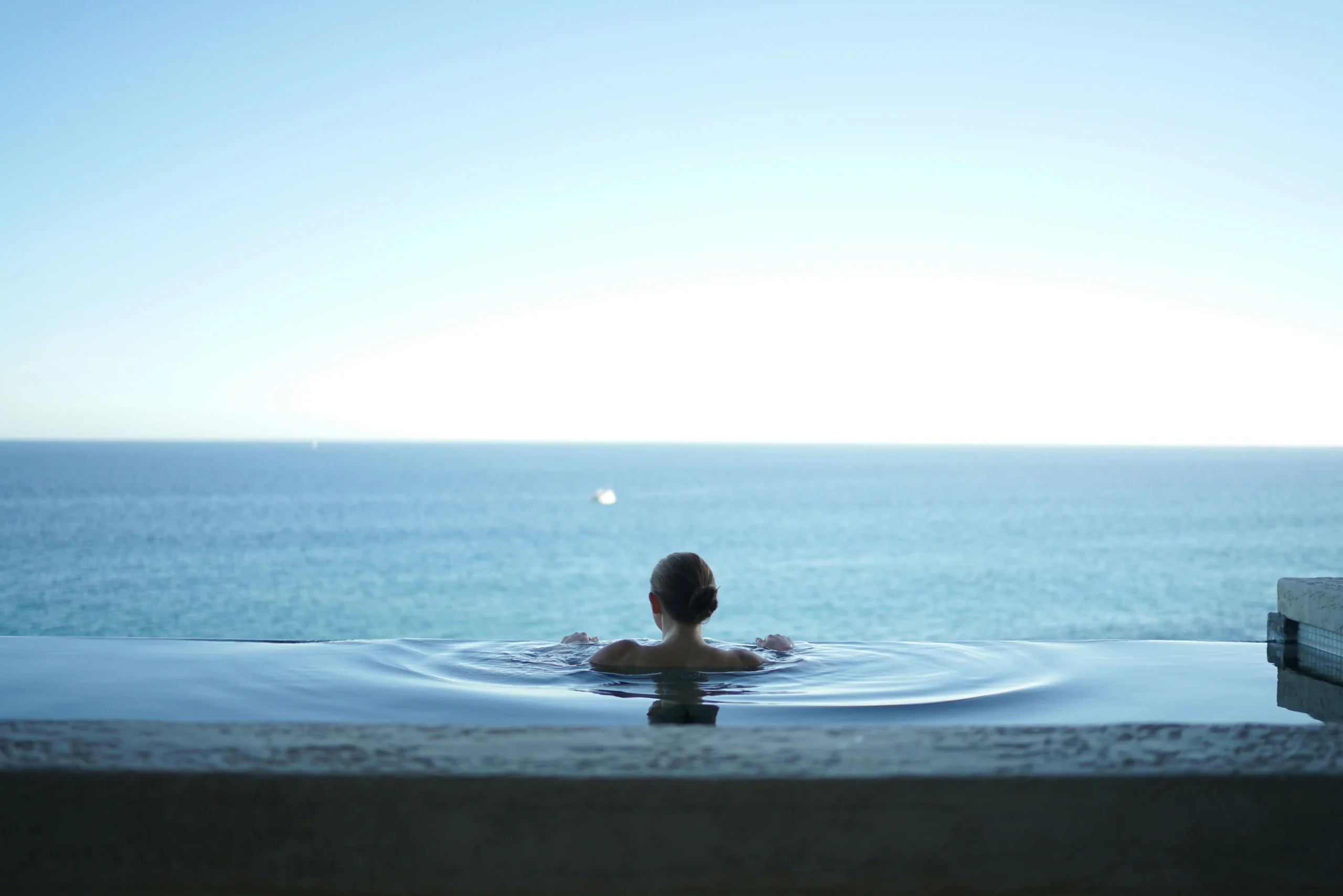 woman in a pool looking at the sea, St Martin, FWI